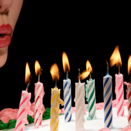 Woman blowing out birthday candles on a cake.