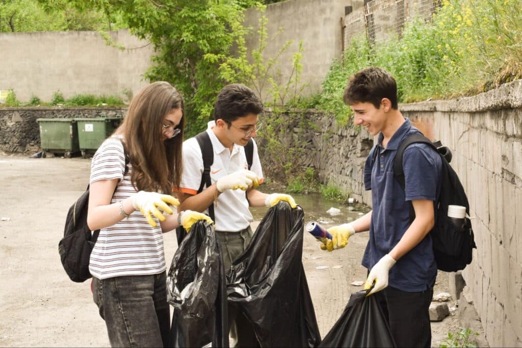 Caption: Students laughing as they pick up trash