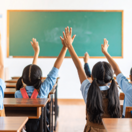 Children raising hands in a classroom